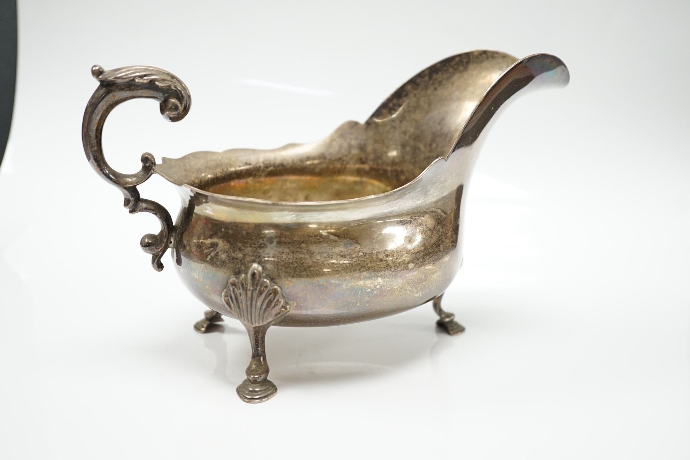 A late Victorian silver sauce boat, with flying scroll handle, Charles Boyton, London, 1897, length 21.6cm, 14.1oz.